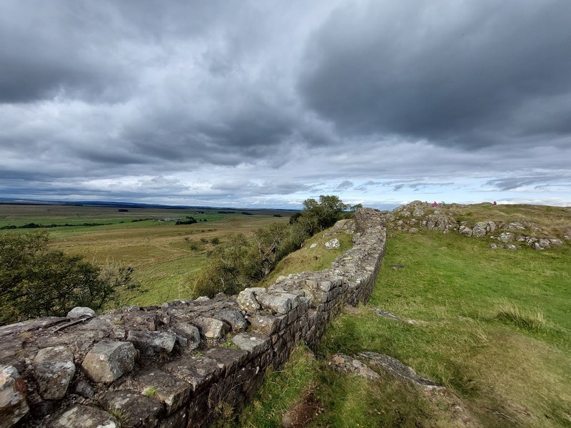alt="a stretch of Hadrian's Wall at Walltown Country Park with moody skies behind"