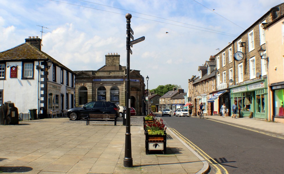 alt="Haltwhistle main street and market square on a sunny day"