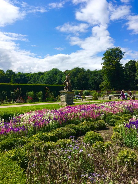 alt="formal gardens at Seaton Delaval with flowers in bloom"