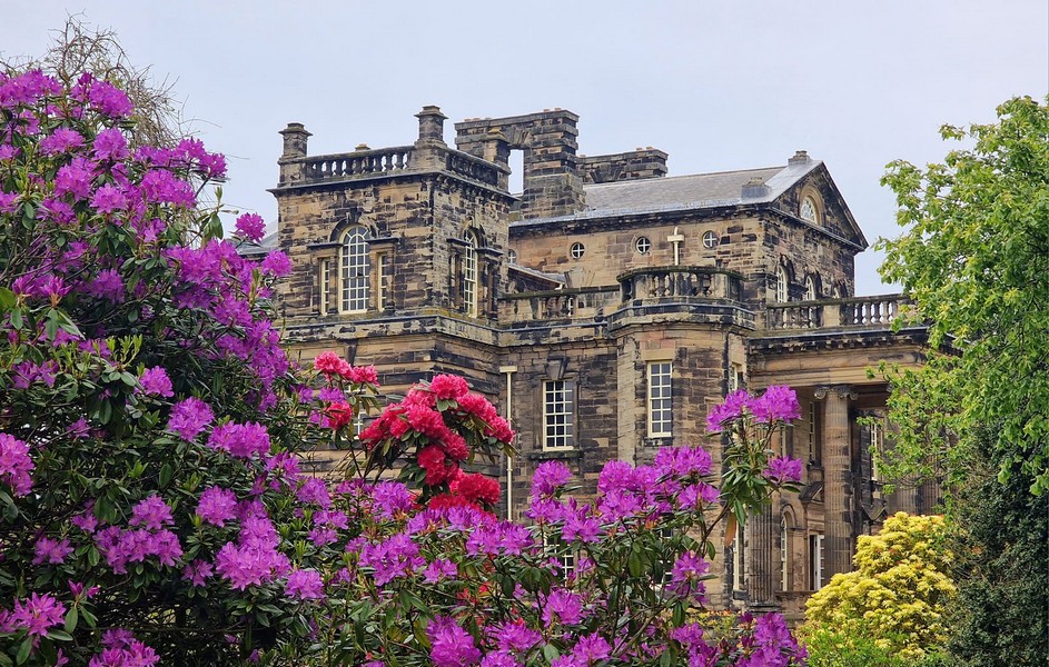 alt="Seaton Delaval Hall side image with rhododendrons in bloom"